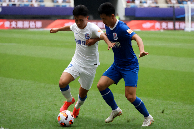足球比赛直播画面，球员在绿茵场上争抢球权