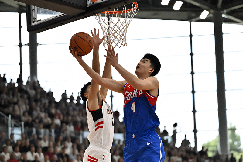 NBA 比赛中球员突破上篮，篮筐下防守球员起跳封盖